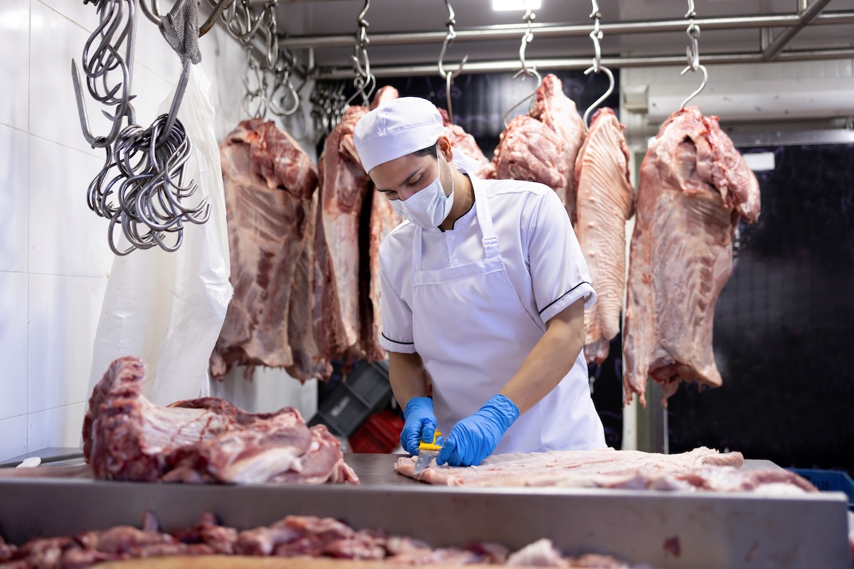 Food production facility workers processing meat